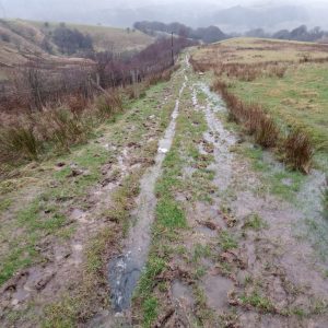 The image shows the Pennine Bridleway near Holme Chapel before maintenance work was carried out in 2022. The ground is saturated with water.